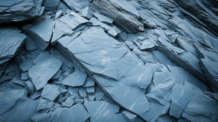 A pile of shattered grey rough hewn stones with sharp edges creates a textured natural background
