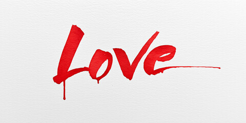 Red watercolor word love painted on white textured paper.