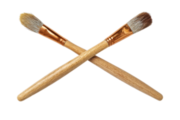 Two crossed paintbrushes with wooden handles and detailed bristles isolated on transparent background.
