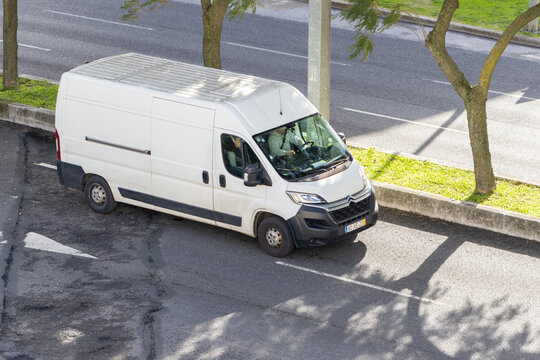 White delivery van driving on urban street