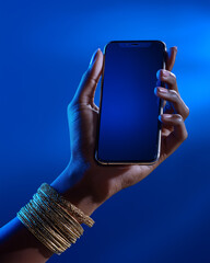 Hand holding smartphone with blank screen on blue background ai generated
