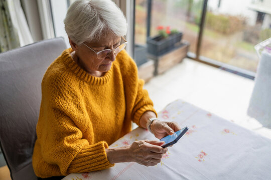 Senior woman using smart phone at home
