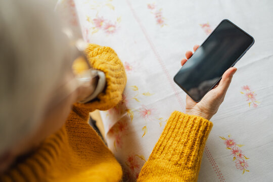 Senior woman using smart phone at home

