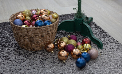 Wicker basket filled with Christmas baubles during holiday cleanup