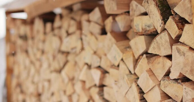 Firewood on winter background from dry chopped firewood in pile. Firewood for the fireplace or campfire stacked in rows. Cold winter.
