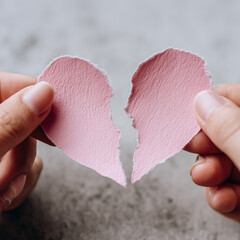 person tearing a valentine card in half