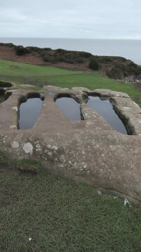 4K: Stone Graves in Heysham, Lancashire. Empty historic and atmospheric Tombs in the concrete. Vertical. Stock Video Clip Footage