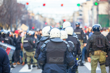 Riot police line in winter city street protest, crowd control, civil unrest and public...