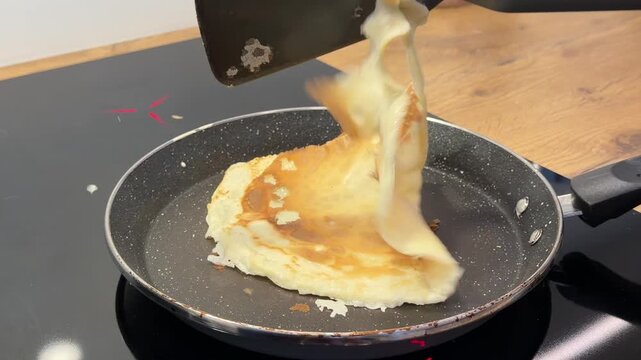 Using a Spatula to Flip a Thin Pancake in a Frying Pan