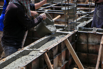 Construction Workers Pouring Concrete into Beam Formwork.