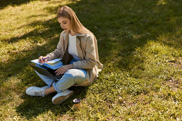 Stylish young woman enjoying a sunny day outdoors while studying in springtime