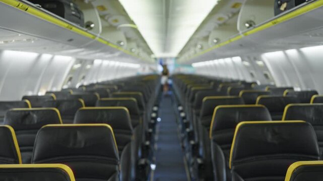 Airplane cabin rows of leather seats and overhead bins soft blurred bokeh aisle leading into defocused interior; background backplate copyspace template.