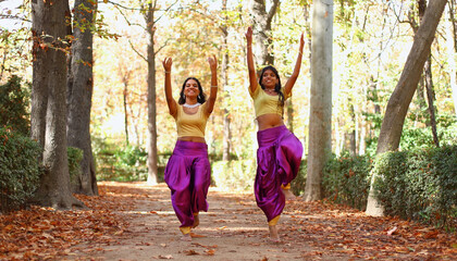 Indian women dancing in traditional clothes in autumn park