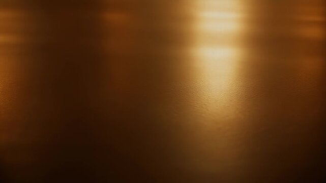 A textured, golden-brown surface with a soft, diffused light source reflecting a gradient of tones. Subtle, organic patterns appear