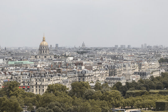 View of rooftops and buildings, including the golden dome of Les Invalides, stretch across the horizon in a dense urban landscape, Paris, &Atilde;Žle-de-France, France.