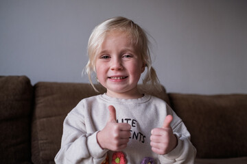 Little girl, 4 years old, showing thumbs up