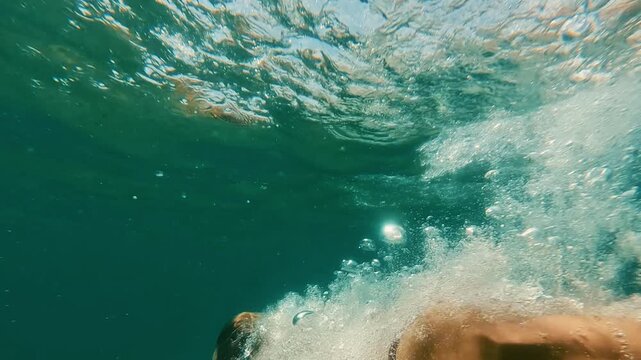 Persona nadando bajo el agua en el mar Mediterr&aacute;neo con luz natural