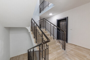 Modern stair case between floors. Stairs with metallic rail in modern building. Interior of a contemporary apartment or office building. Architecture and real estate background.