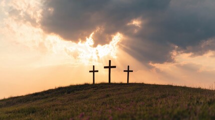 Obraz premium Crosses stand on a hill during sunset surrounded by clouds and light