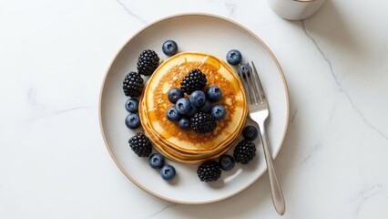 Delicious stack of golden pancakes with berries, syrup, and fork