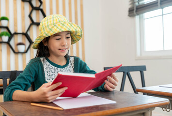 Smiling exchange student girl reading a book in classroom