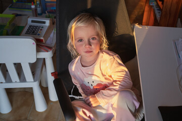 Bored 4-Year-Old Child Waiting in Big Computer Chair.