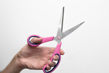 Męska dłoń trzymająca nożyczki. Zdjęcie na białym tle. © hunter76