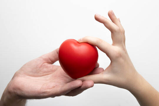 Dłonie ojca i dziecka trzymające serce. Zdjęcie na białym tle.

