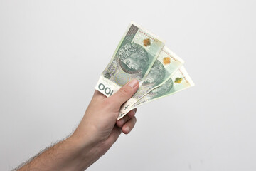 Męska dłoń trzymająca banknoty, złotówki, Zdjęcie na białym tle. © hunter76