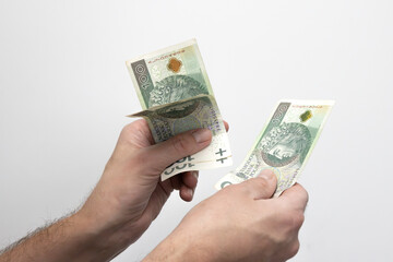 Męska dłoń trzymająca banknoty, złotówki, Zdjęcie na białym tle. © hunter76