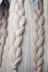 Close-up of braided hair extensions in various shades of blonde and brown