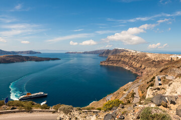 Ferry arrives at the port of Santorini Island, Greece. View of the road to the port. Blue sea and the blue sky at sunny day