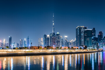 Obraz premium Dubai downtown night city skyline. Modern skyscrapers and lights are reflected in the water canal.
