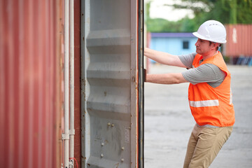 Worker is opening a shipping container and inspecting at the port