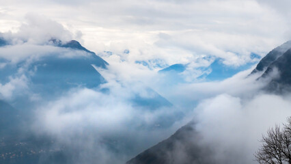 Morning fog at Como, Italy. Clouds over the Alps mountains and Como lake.