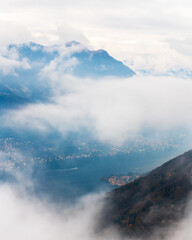 Morning fog at Como lake, Italy. Clouds over the Alps mountains and lake Como. View from Brunate mountain.