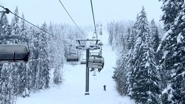 a working chairlift at the ski resort in winter with white snow-covered pines. High quality 4k footage