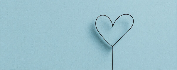 Delicate wire heart on a serene blue background, symbolizing affection and minimalist charm