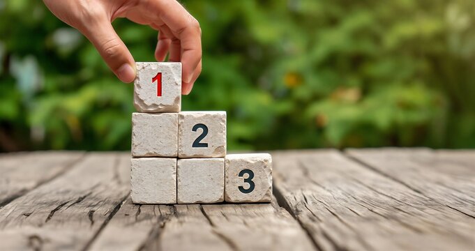 Hand placing numbered wooden blocks in sequence on table