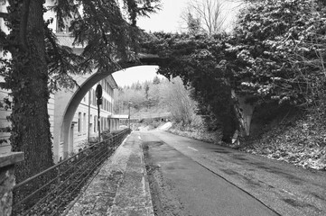 Ancient Arched Structure Crossing Deserted Road Amidst Snowcovered Banks And Leafless Trees