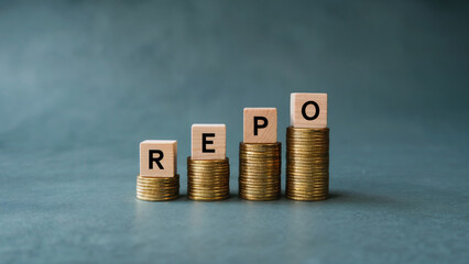 REPO Rate Concept with Wooden Blocks on Increasing Stacks of Gold Coins