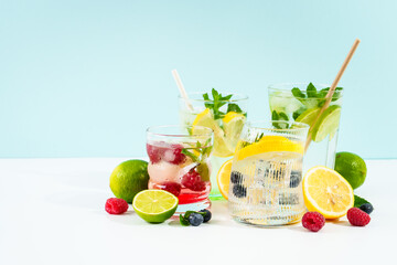 Fototapeta premium Lemonade set on colored background. Lemonade, mojito, raspberry lemonade and blueberry lemonade.