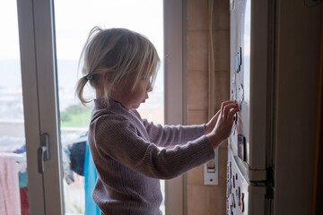 4-Year-Old Child Arranging Colorful Fridge Magnets.