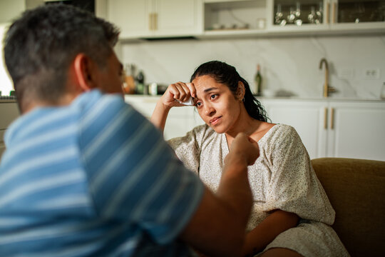 Adult couple arguing, sad woman crying in home kitchen
