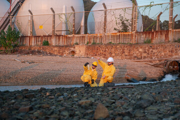 Environmental engineers conducting water inspection near industrial gas storage facility.