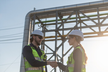 Industrial engineers collaborating on technical project at refinery plant, project management and modern construction technology, Oil and Gas Petrochemical industry.