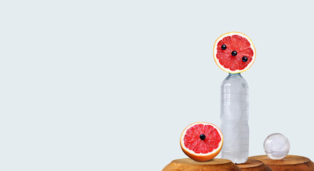 Energetic drinks, isotonic, ice cold conceptual image. Modern drinks wallpaper, sustainability, sliced ​​grapefruit with black berry, frosty plastic bottle. Image manipulation, copy space