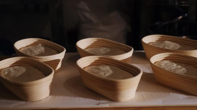 Before baking, the sourdough rests in proofing baskets on the table. Manual fermentation, a professional process, raw dough texture, traditional bread making. Morning pastry.
