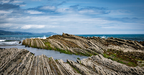 itzurun beach or zumaia beach in spain with blue sky
