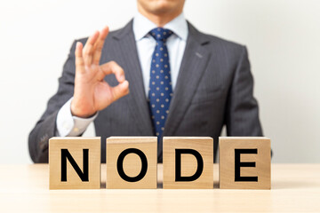 「NODE」と書かれたブロックとOKポーズをするビジネスマン